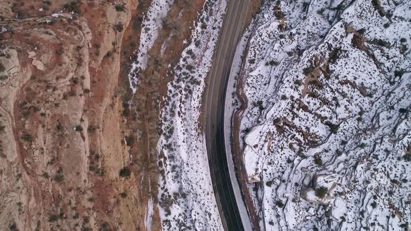 Aerial view looking down at car driving on road in the desert