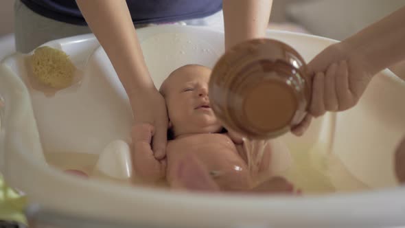 Mum and grandma bathing baby