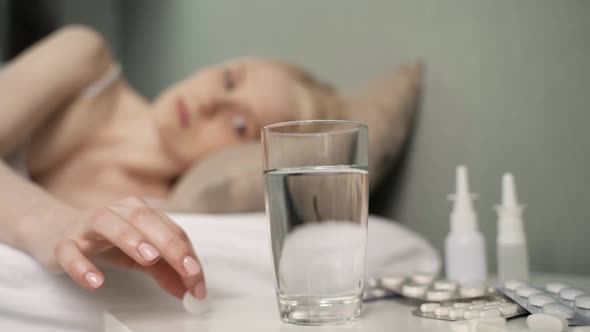 Sick Woman Lies and Coughs on Bed at Home Throws Antipyretic Effervescent Tablet Into Glass of Water