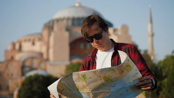 Man Tourist Looking at Map Against Ayasofya Mosque Travel Concept