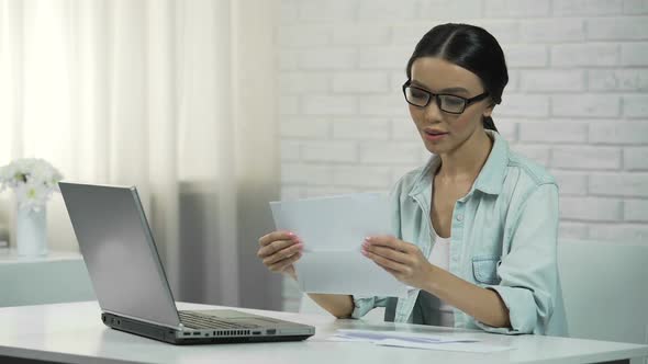 Woman Typing on Laptop at Home, Paying for Utilities or Checking Correspondence