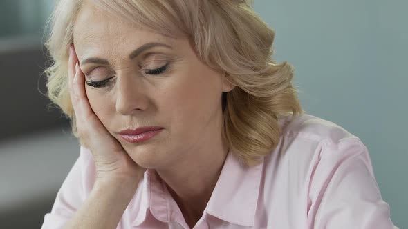 Overworked Mature Woman Sleeping at Workplace, Lack of Sleep and Vitamins