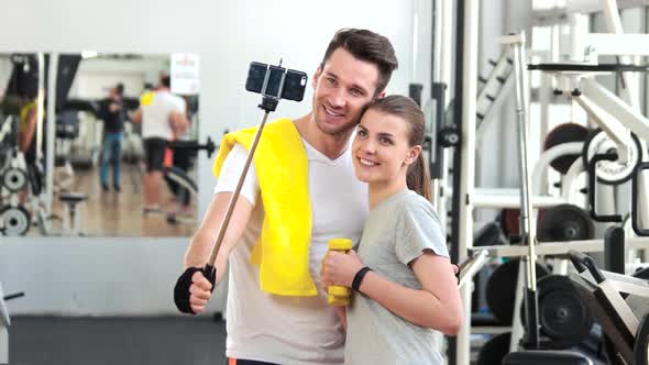 Smiling Couple Talking a Selfie at Gym.