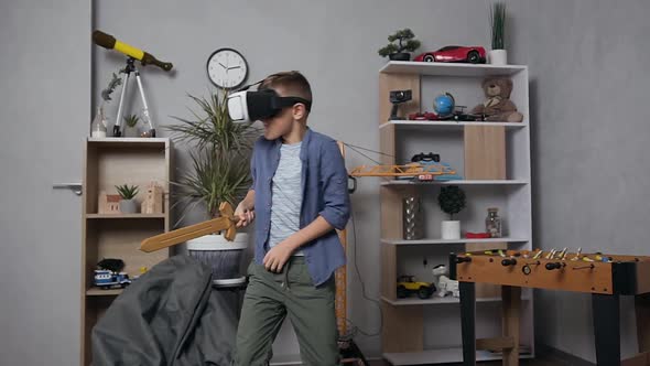 Teenage Boy Fighting with Toy Sword in Special Virtual 3d Glasses in His Playroom alt