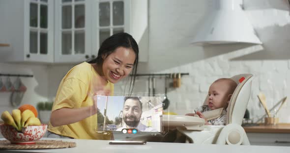 Mother and Baby Having Video Chat with Father