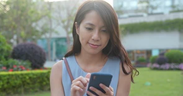 Woman look at the mobile phone in park