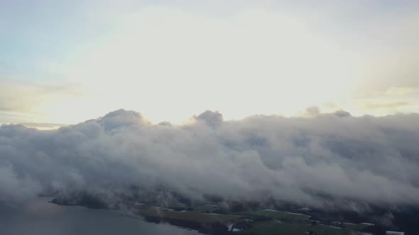 Aerial view running clouds over green forest and lake.