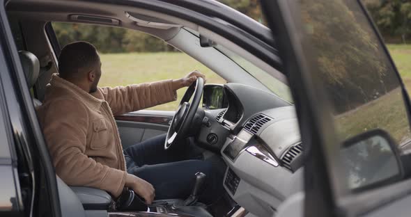 Side View of Black Driver Behind the Wheel