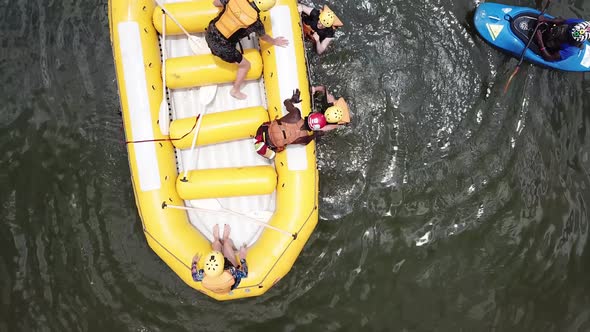 Rafting instructor helping tourists to board the rafting boat. Drone aerial view.