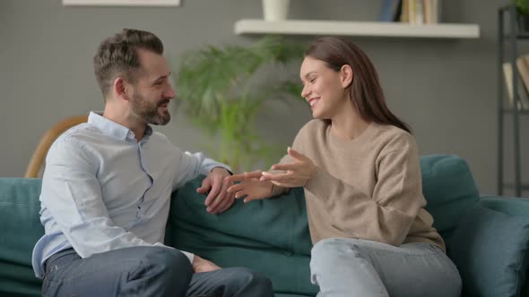 Woman Talking to Man While Sitting on Sofa