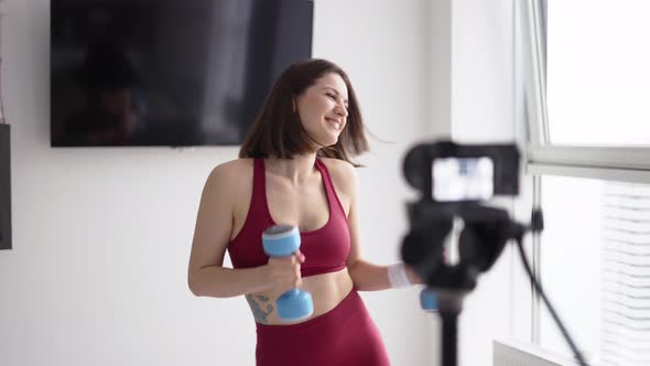 Woman Fitness Instructor Records a Tutorial Training While Dancing with Dumbbells