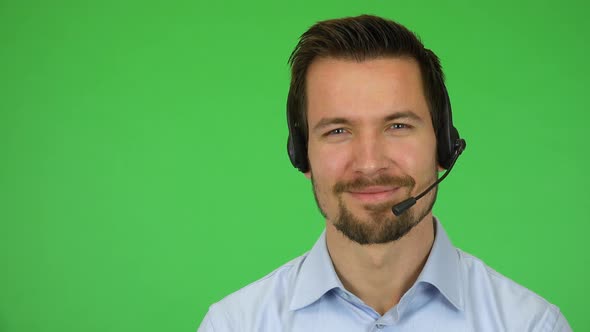 A Young Handsome Call Center Agent Turns To the Camera and Smiles - Closeup - Green Screen Studio