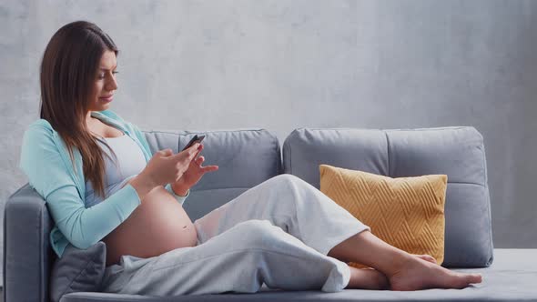 Young pregnant woman is resting at home and expecting a baby.