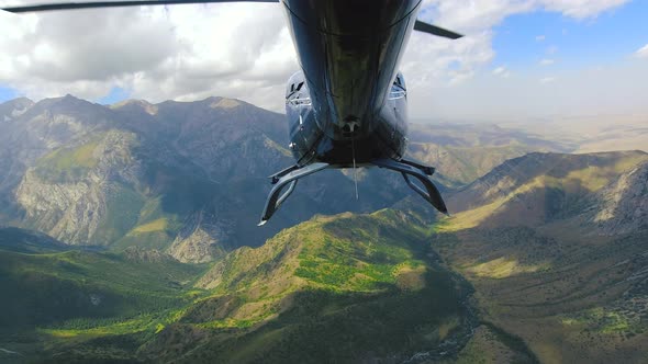 Helicopter View From the Tail Section Flying Over Mountain Landscape