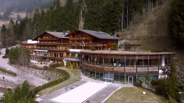 Aerial View of the Luxury Hotel in Alps with a Man Sitting on the Roof