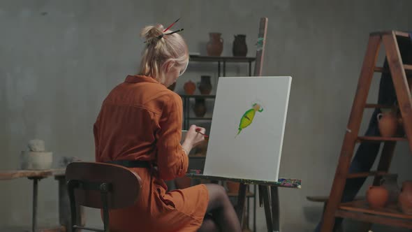 Woman Painter Creating Colorful Painting in Workshop