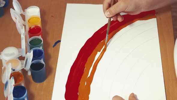 The Rainbow is Drawn By Children's Hands in Closeup with Colored Paints