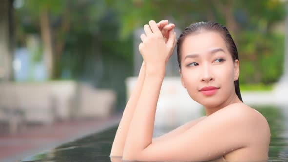 Young asian woman enjoy around outdoor swimming pool for leisure