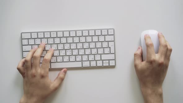 Male Hands Typing on a White Computer Keyboard