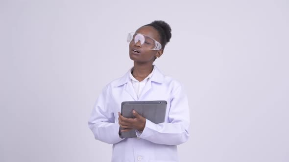 Young Happy African Woman Scientist Thinking While Using Digital Tablet