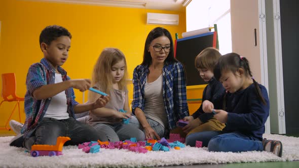 Diverse Kids Playing with Constructing Toy Blocks