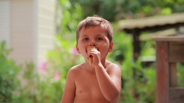 The Cute Cheerful Boy Is Eating a Cone Ice Cream and Showing Big Thumb