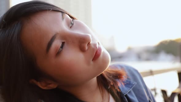 Portrait of beautiful Asian woman enjoying a peaceful sunset in Bangkok Thailand.