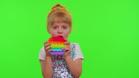 Stylish Child Girl Playing Colorful Squishy Silicone Bubbles Sensory Pop It Toy Game on Chroma Key