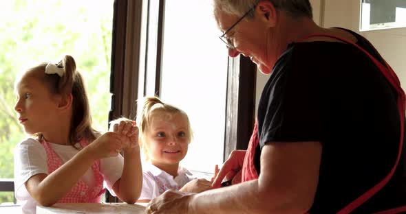 Close Up of Two Girls Cooking Pasta with Grandma