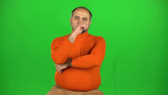 Full Caucasian Man Looking at Camera, Listens Attentively Stroking a Beard. Green Screen