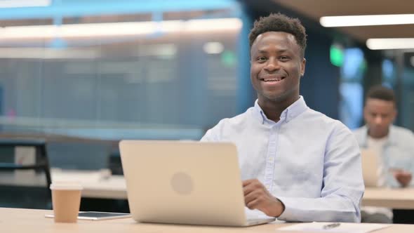 African Businessman with Laptop Smiling at Camera