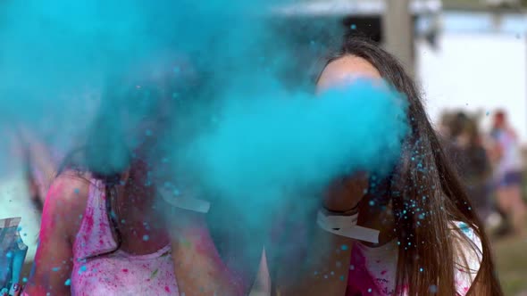 Happy Girls Hold Holi Colors in Their Hands and Blow Them Into the Camera
