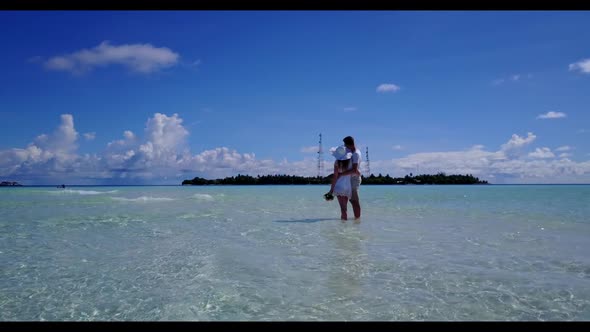 Romantic couple happy together on marine shore beach voyage by shallow water and white sandy backgro