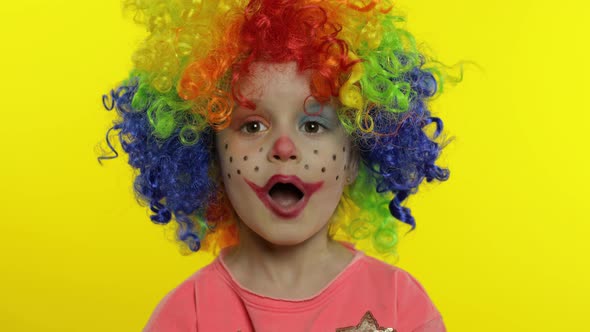 Little Child Girl Clown in Wig Making Silly Faces, Fool Around, Singing, Showing Tongue, Halloween
