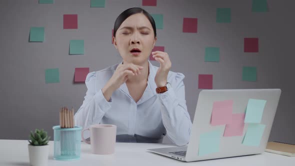 Asian woman working on a laptop was sick with fever sneezing and sitting