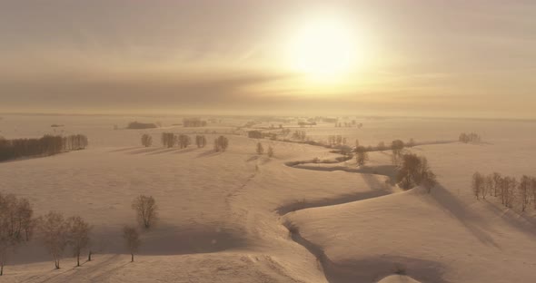 Aerial View of Cold Winter Landscape Arctic Field Trees Covered with Frost Snow Ice River and Sun