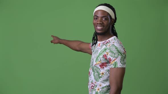 Young Handsome African Man with Dreadlocks Against Green Background