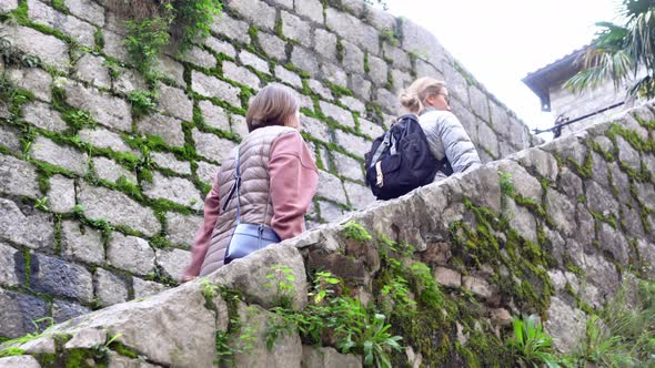 Two Women Goes Up Stone Staircase Side View From Below