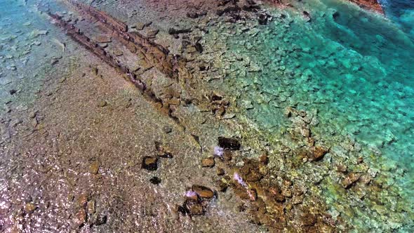 Clear and Shallow Sea Water of the Cove Surrounded by Stone and Rocky Coastline