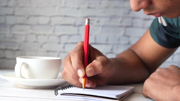 a Boy Drawing with Colored Pencil on a Page.