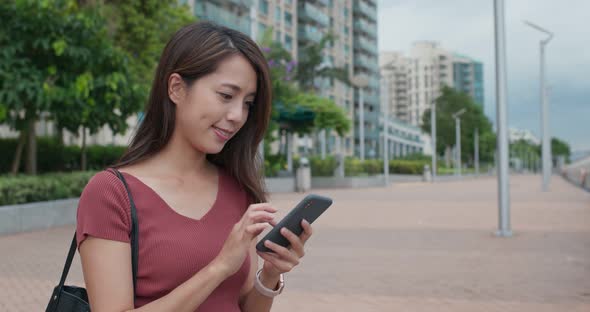 Woman look at smart phone in the street