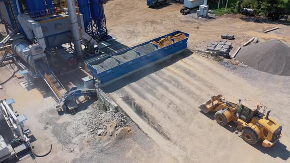 View from above on asphalt factory. Excavator working outdoors.