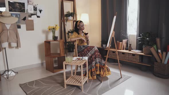 Woman Drinking Wine after Painting at Home