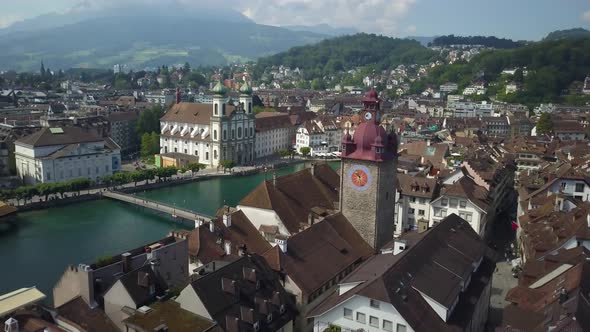 Aerial orbit of Lucerne Old Town picturesque rooftops, Jesuit Church, Reuss River and bridges, surro