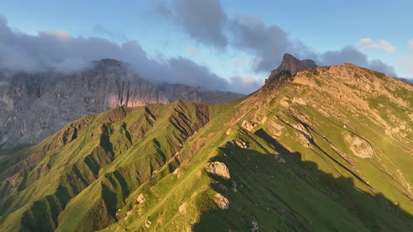 Dolomites mountains peaks with a hiking path on a summer sunrise