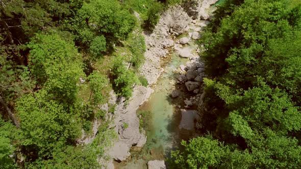 Aerial view of a person going across the Soca River on a zip line in Slovenia.