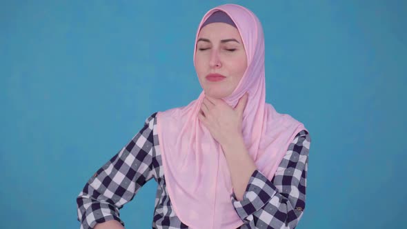 Young Muslim Woman in Hijab Having Trouble with Sore Throatuses Spray To Treat Throat