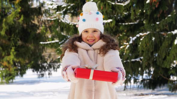 Happy Girl with Christmas Gift in Winter Park