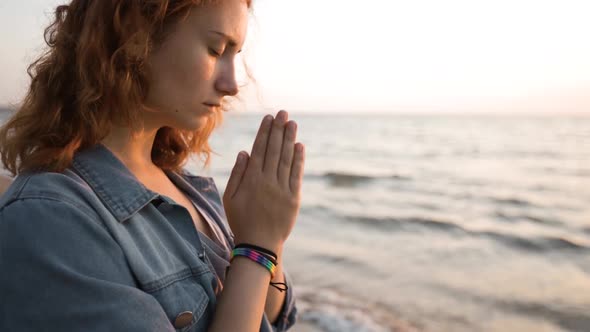 LGBT Pride: Woman Wears Rainbow Bracelet and Prays at Sea