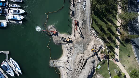 Large construction machinery on a infrastructure project excavating sand and debris from the ocean n